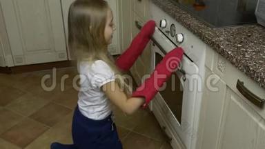 快乐的小女孩在家里的厨房里烤饼干。 家用电器和自制糕点。 年轻的白人女孩